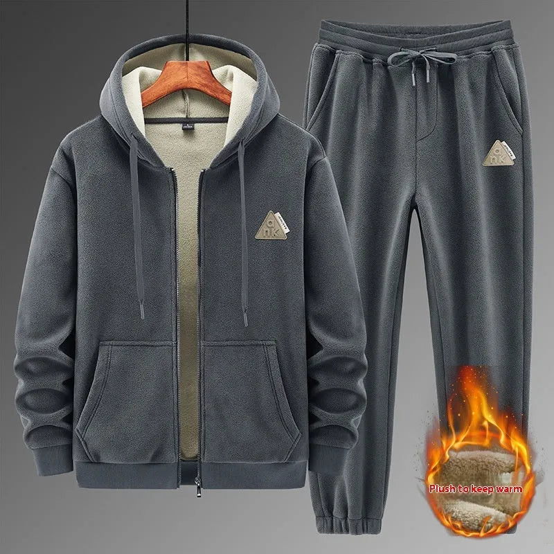 Man wearing a grey hooded cashmere sweater and matching cotton trousers from a casual sports suit.