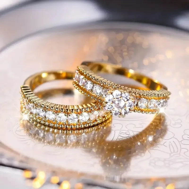 Two geometric gold electroplated zinc alloy rings on a flat surface