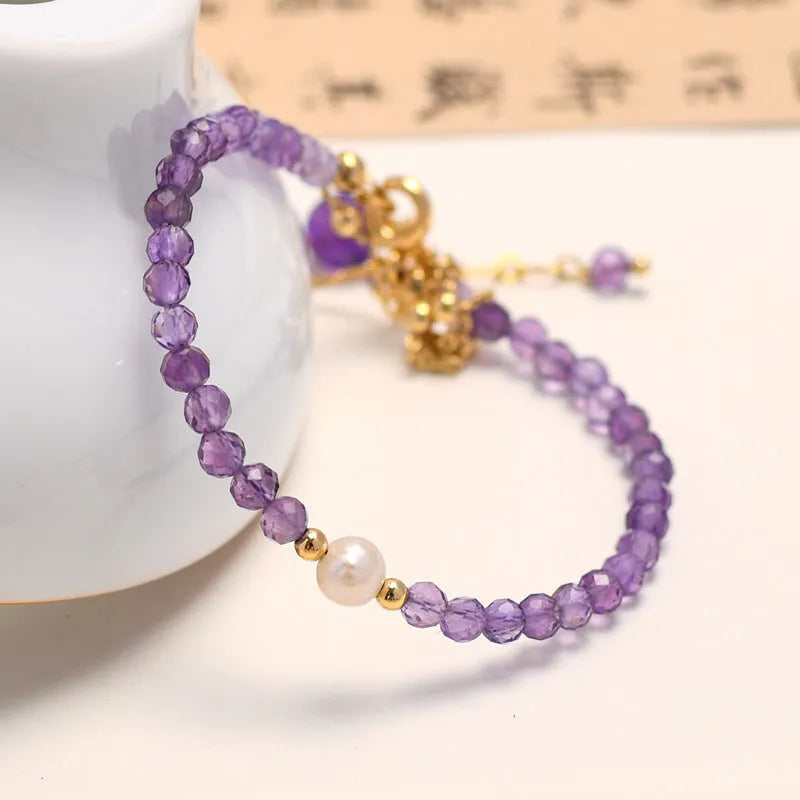 Chinese style women's bracelet with electroplated metal and amethyst crystal stones cut in diamond shapes.