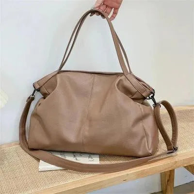 Large soft surface messenger bag showing horizontal square shape with adjustable shoulder strap and zip opening