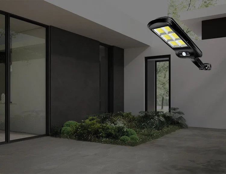 Black solar-powered outdoor wall light with motion sensor for garden and driveway security.
