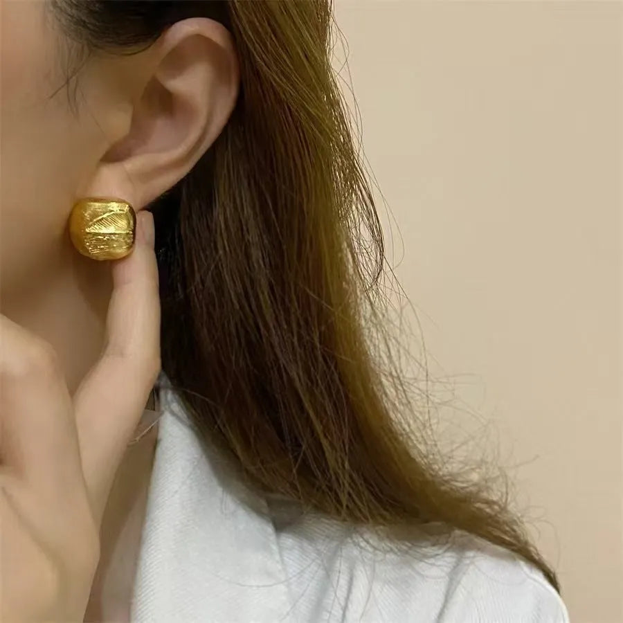 Minimalist metal alloy stud earrings with a simple circle design on a white background.