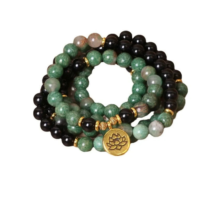 Green and black alloy elastic beaded bracelet on a wrist.