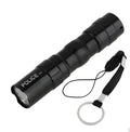 Small black aluminium alloy LED mini flashlight showing scale next to a AA battery.