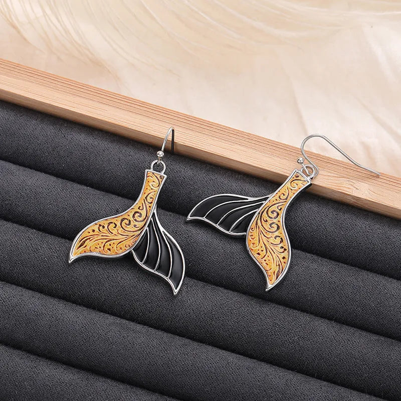 Women's white gold fishtail earrings with whale elements and retro styling