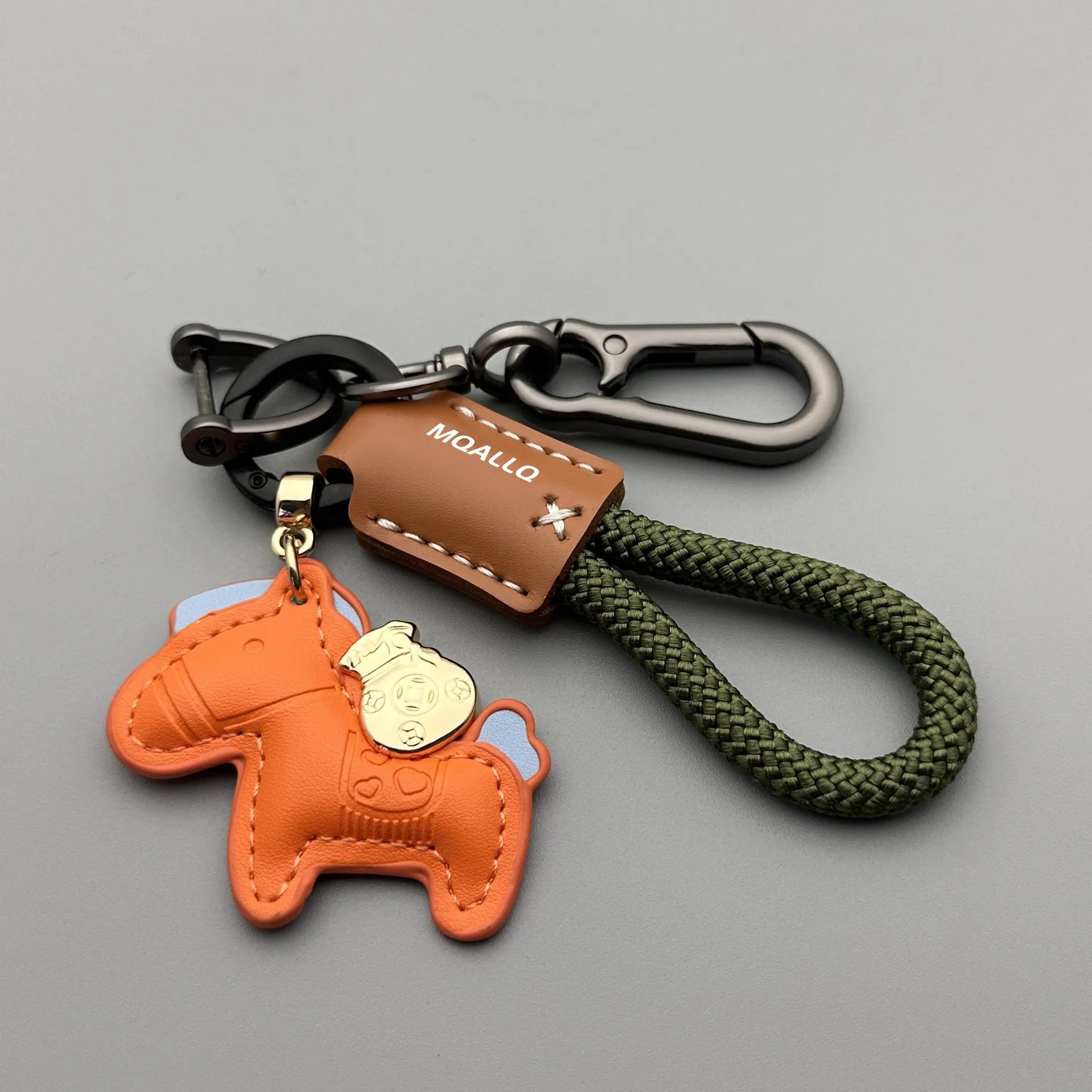 Handmade brown cowhide key pendant with a green flannel rope and a gold-toned horse-shaped buckle.