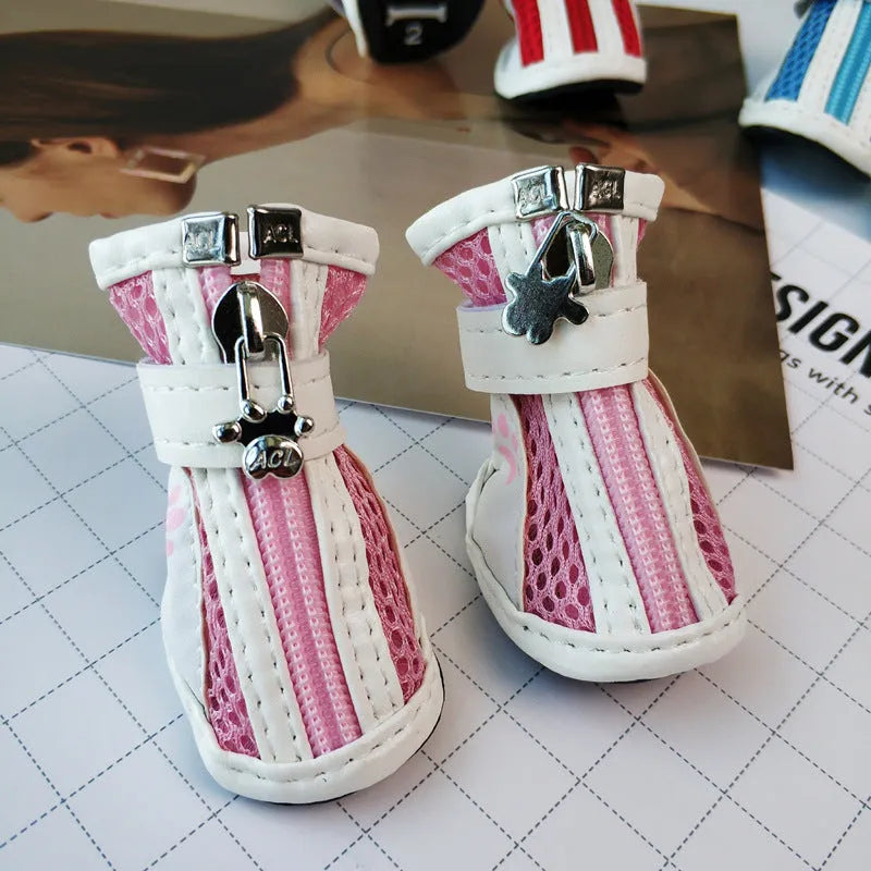 Four blue cloth dog shoes with zipper closures and non-slip soles arranged together