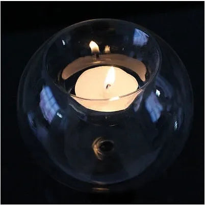 Handmade European hollow glass candle holder in round geometric design on table.