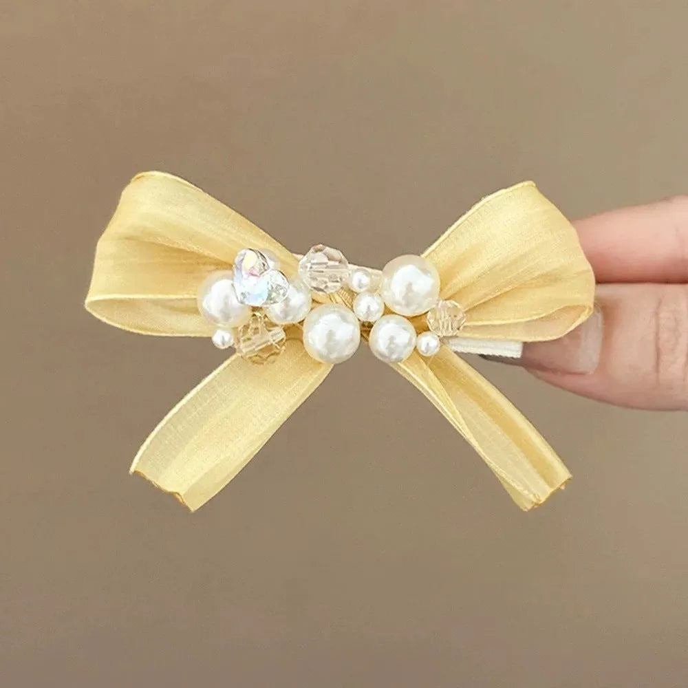 Yellow bow barrette with rhinestone and pearl on duckbill clip for women