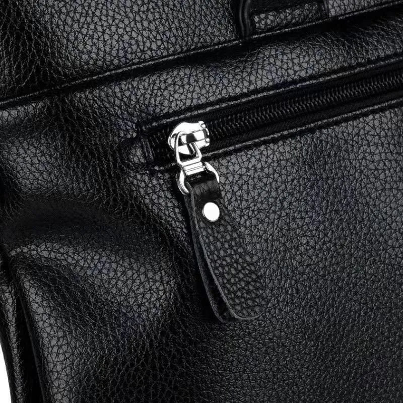 Black PU leather men's shoulder messenger bag with splicing style, shown next to a laptop