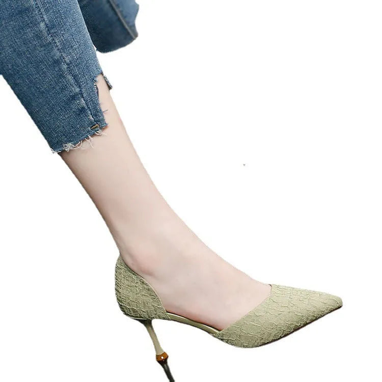 Women's black pointed stiletto heels with 6-8cm heel on wooden surface
