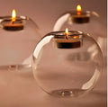 Handmade European hollow glass candle holder in round geometric design on table.