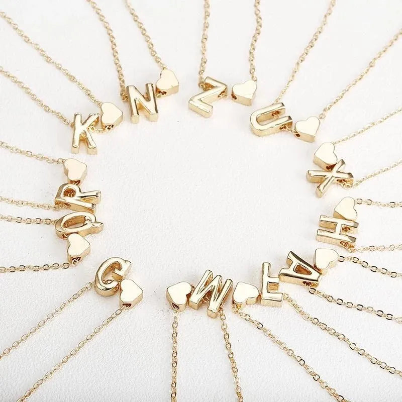 Gold alloy peach heart pendant necklace with a letter detail on a delicate chain.