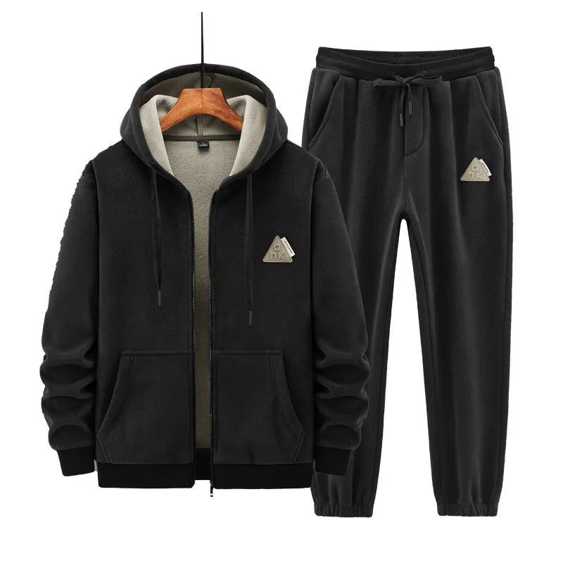 Man wearing a grey hooded cashmere sweater and matching cotton trousers from a casual sports suit.