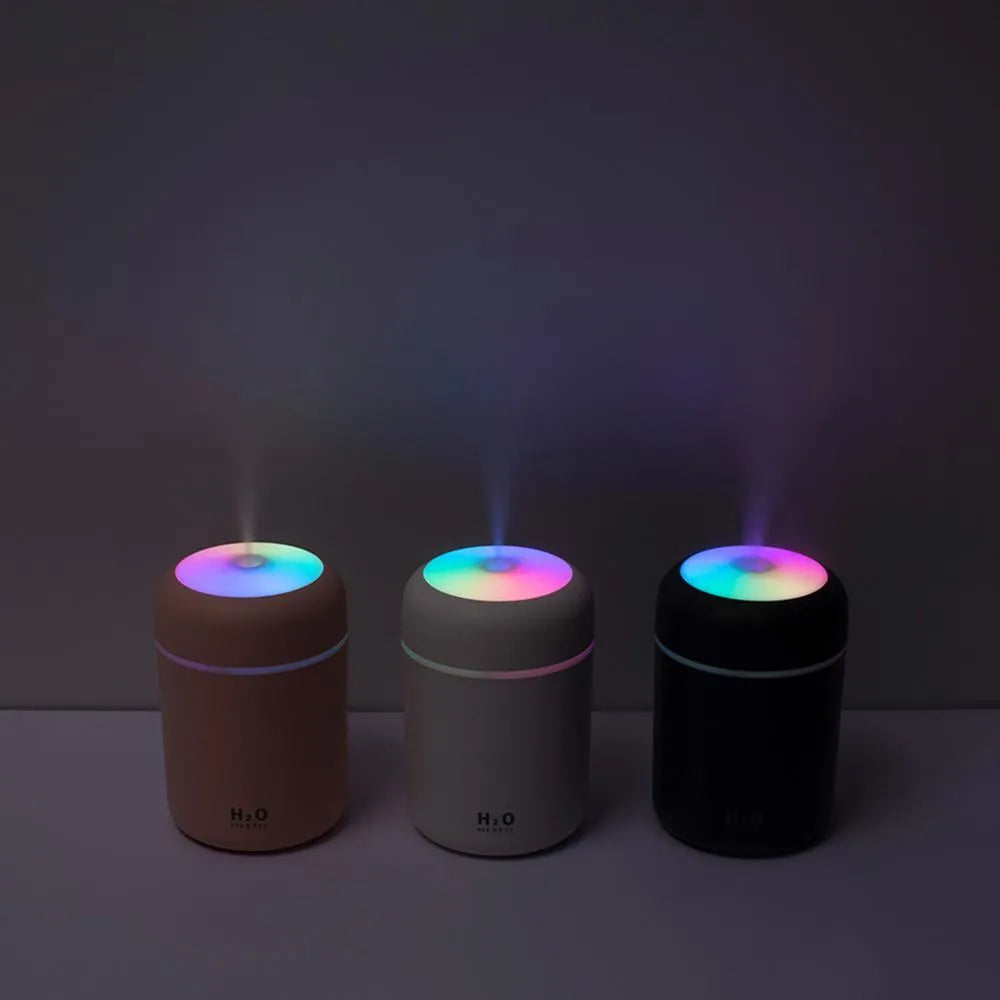 Pink, white or navy blue USB mini humidifier with colourful lights on desk surface