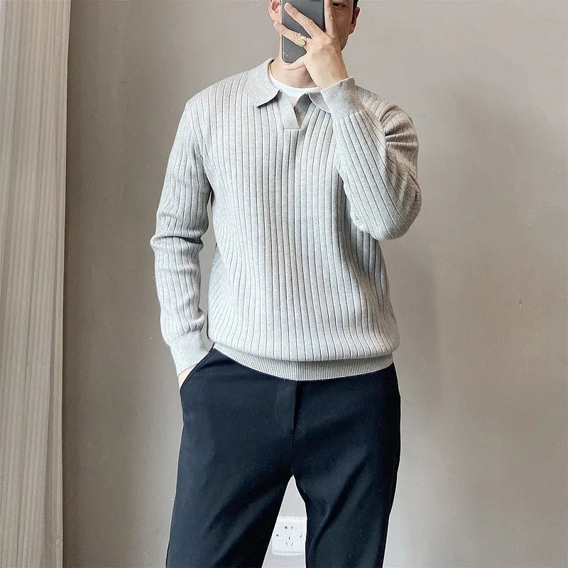 Man wearing a loose black textured knit pullover sweater with long sleeves.