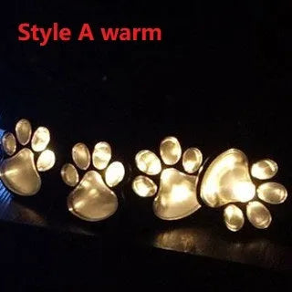 Black solar-powered bear paw print LED garden lights with four paw shapes connected to solar panel