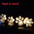 Black solar-powered bear paw print LED garden lights with four paw shapes connected to solar panel
