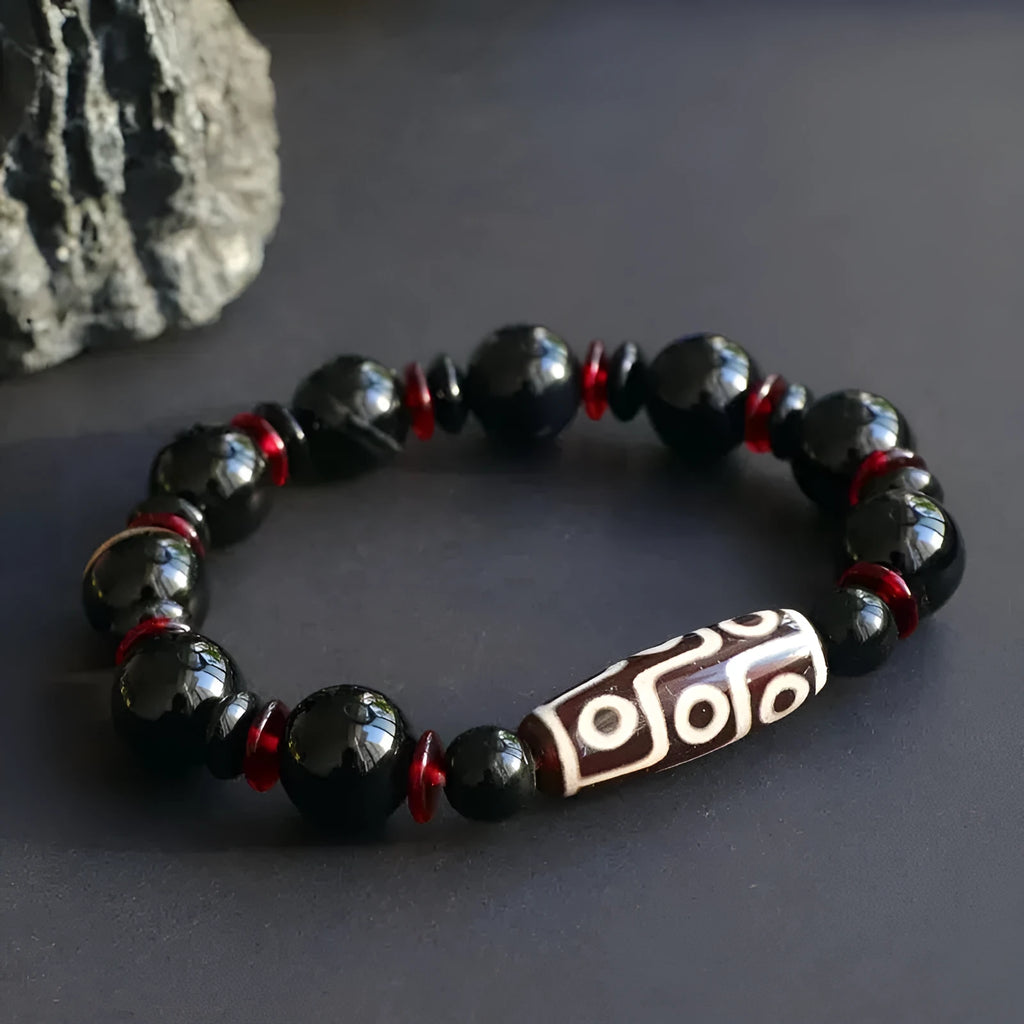 Black agate Dzi bead bracelet with hand-woven construction and geometry beads.