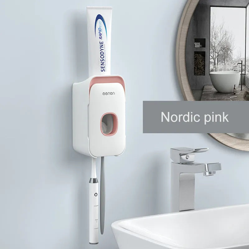 Blue automatic toothpaste dispenser mounted on a bathroom wall with a toothbrush below.