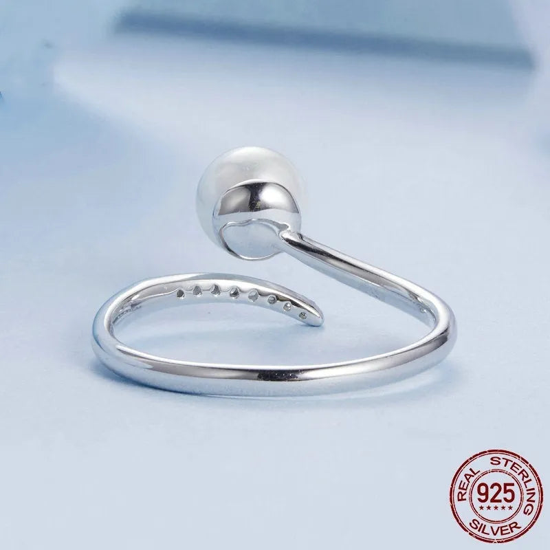 Silver adjustable ring with shell pearls showing open loop design for size adjustment