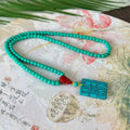 Turquoise lucky pendant necklace with hand-woven mesh flower stone design on a ball bead chain.