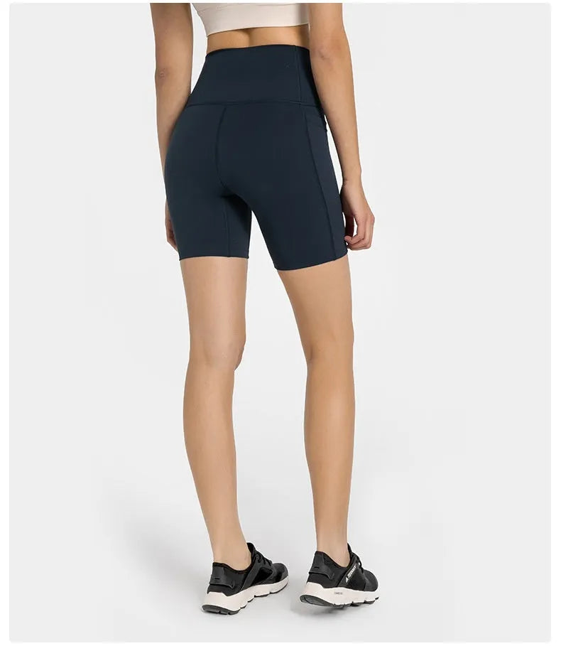 Women's tight-fit cotton blend sports shorts in short fifth pants length on a neutral background.