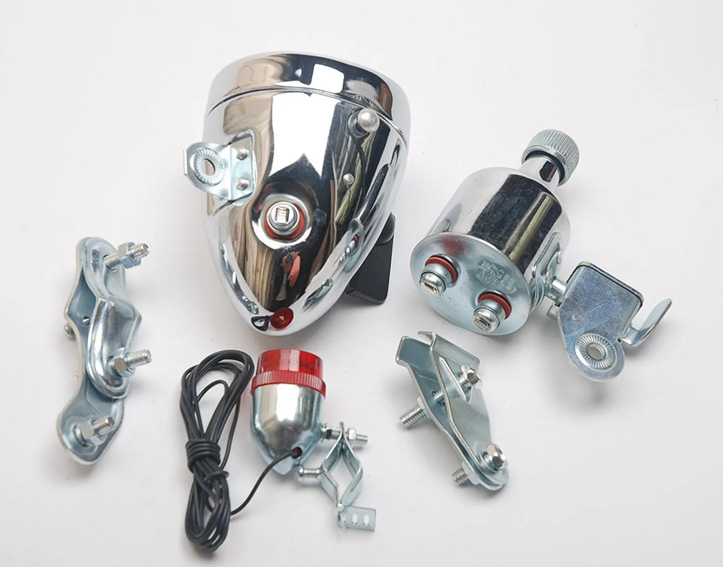 Silver aluminium bicycle dynamo light kit mounted on a bike fork for friction-powered lighting.