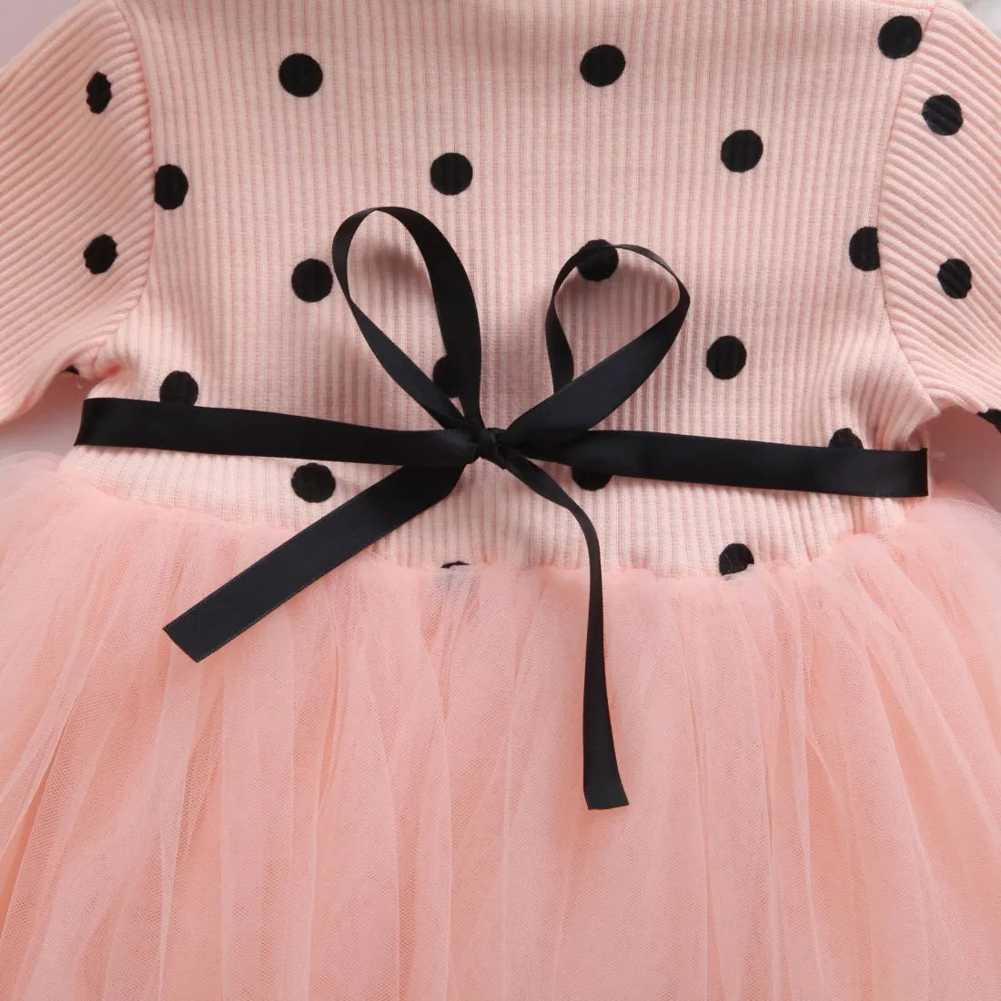 Baby girl in a long sleeve black tutu lace dress for a christening or birthday party.