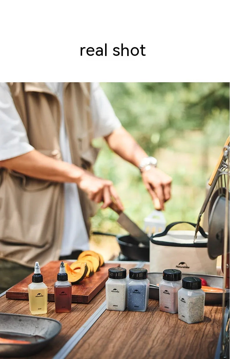 Set of six white portable seasoning bottles with black lids for outdoor picnics and camping.