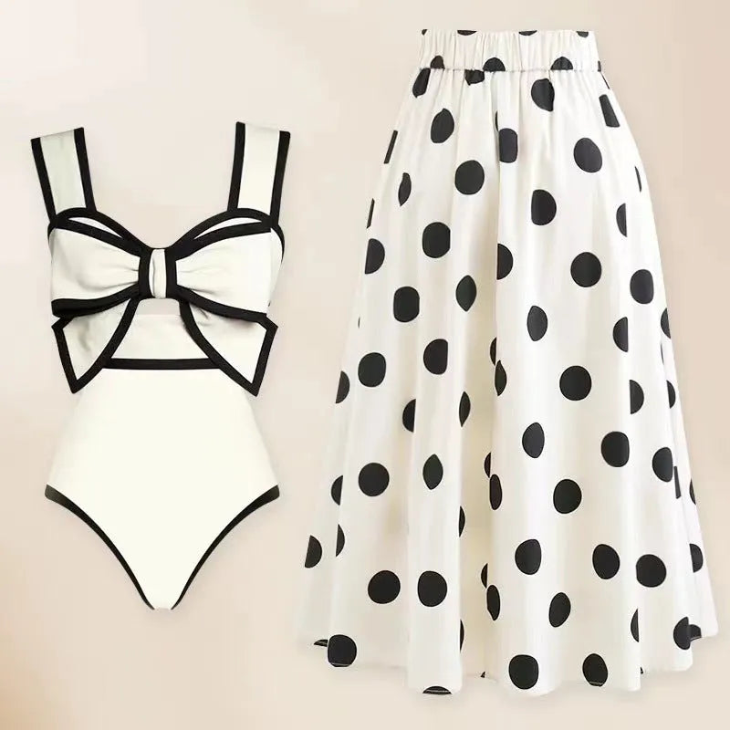 Women's black one-piece swimsuit with a white round skirt and a central bow detail.