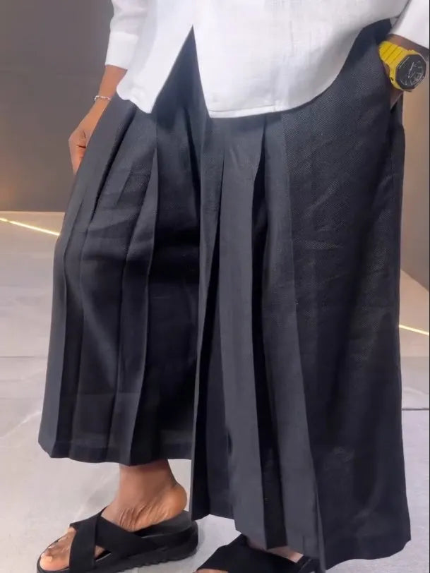 White asymmetrical front long sleeve shirt paired with black pleated trousers in a women's two-piece set.