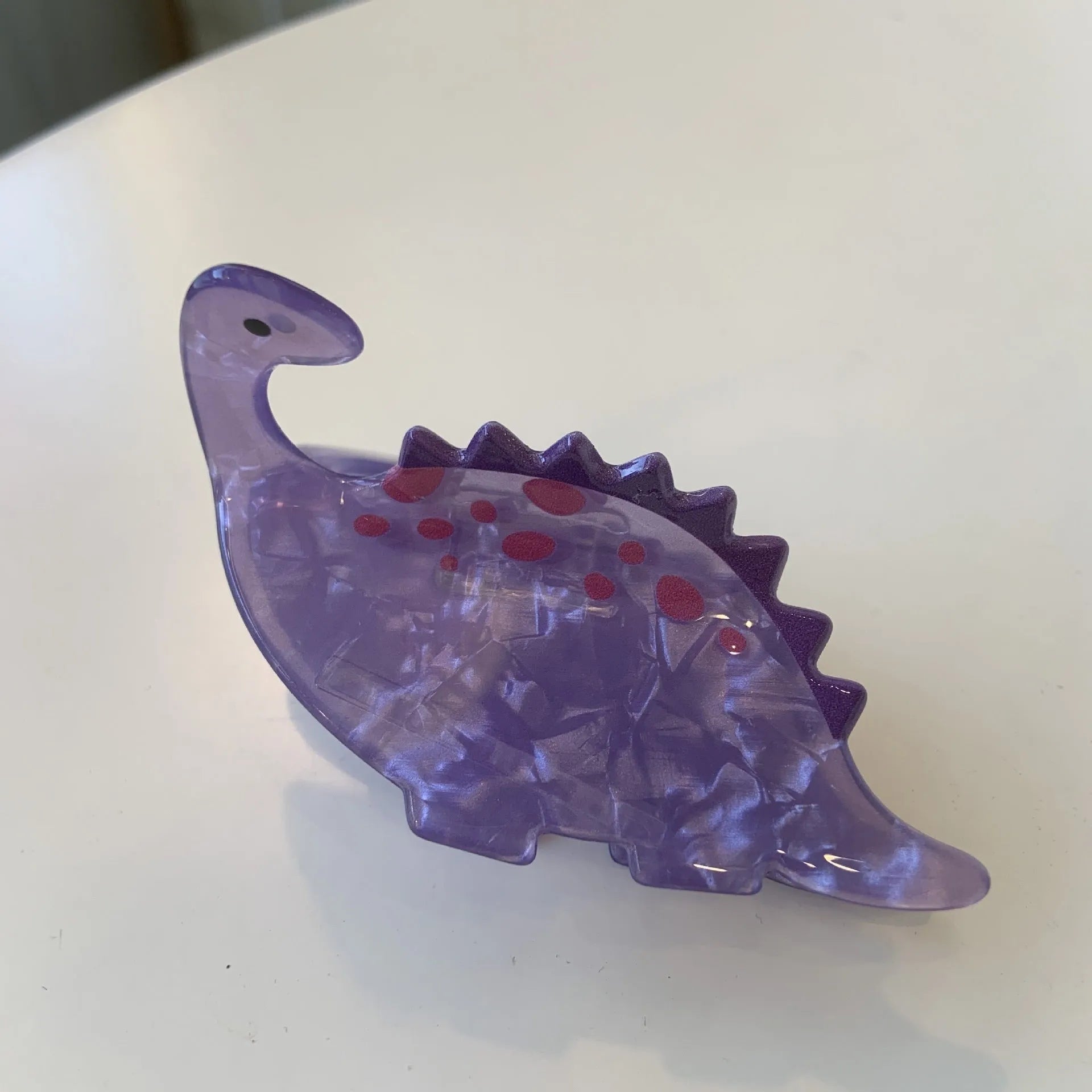 Dinosaur-themed acrylic jaw hair clip showing six colour variations with grip mechanism