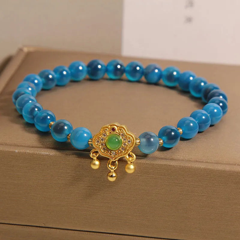 Blue agate safety lock pendant on a women's crystal bracelet with alloy-inlaid gemstones and rhinestones.
