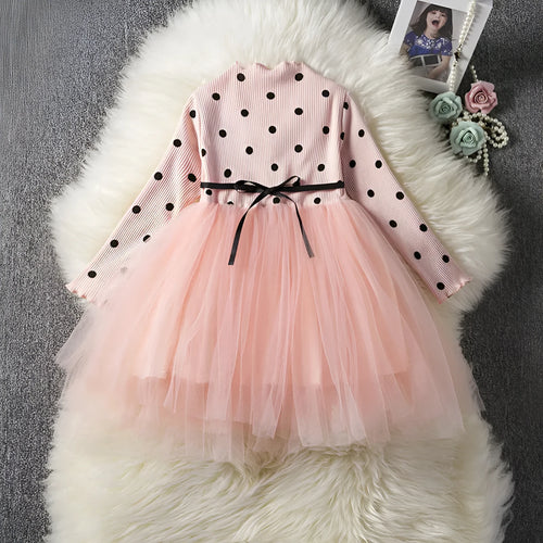 Baby girl in a long sleeve black tutu lace dress for a christening or birthday party.