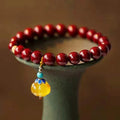 Handcrafted Chinese cinnabar bracelet with gold copper beads in wave design on wrist