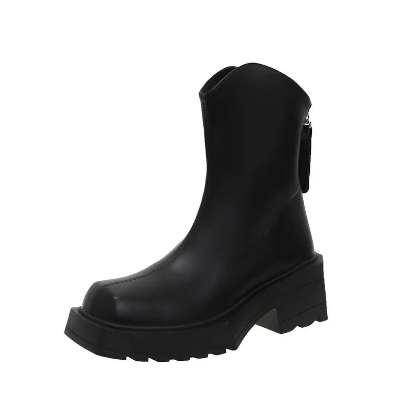 Black women's platform Martin boots with a square toe and back zipper on a wooden floor.
