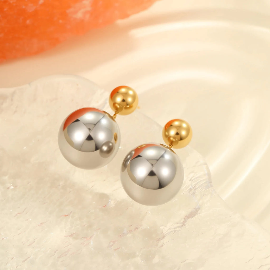 A pair of geometric round bead ear studs with a colour-block finish on stainless steel.