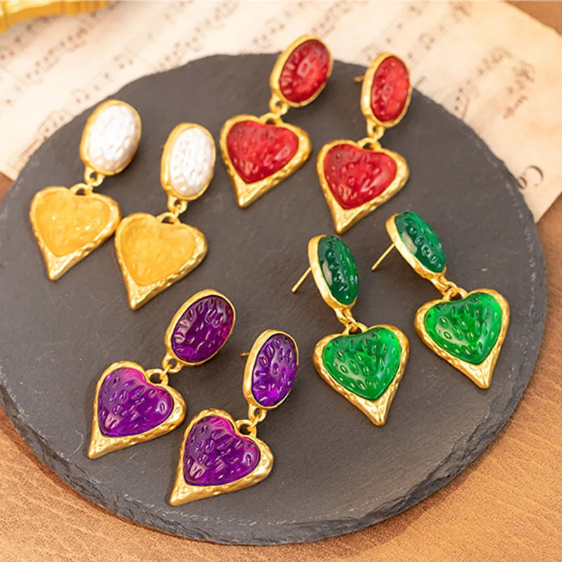 A pair of alloy pleated oval heart-shaped stud earrings with silver posts on a white background.