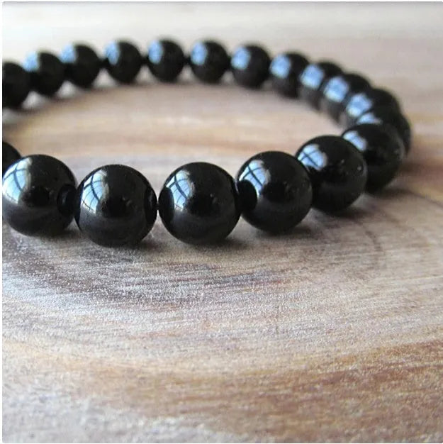 Geometric black agate beaded bracelet with 8mm stones on a black elastic cord.