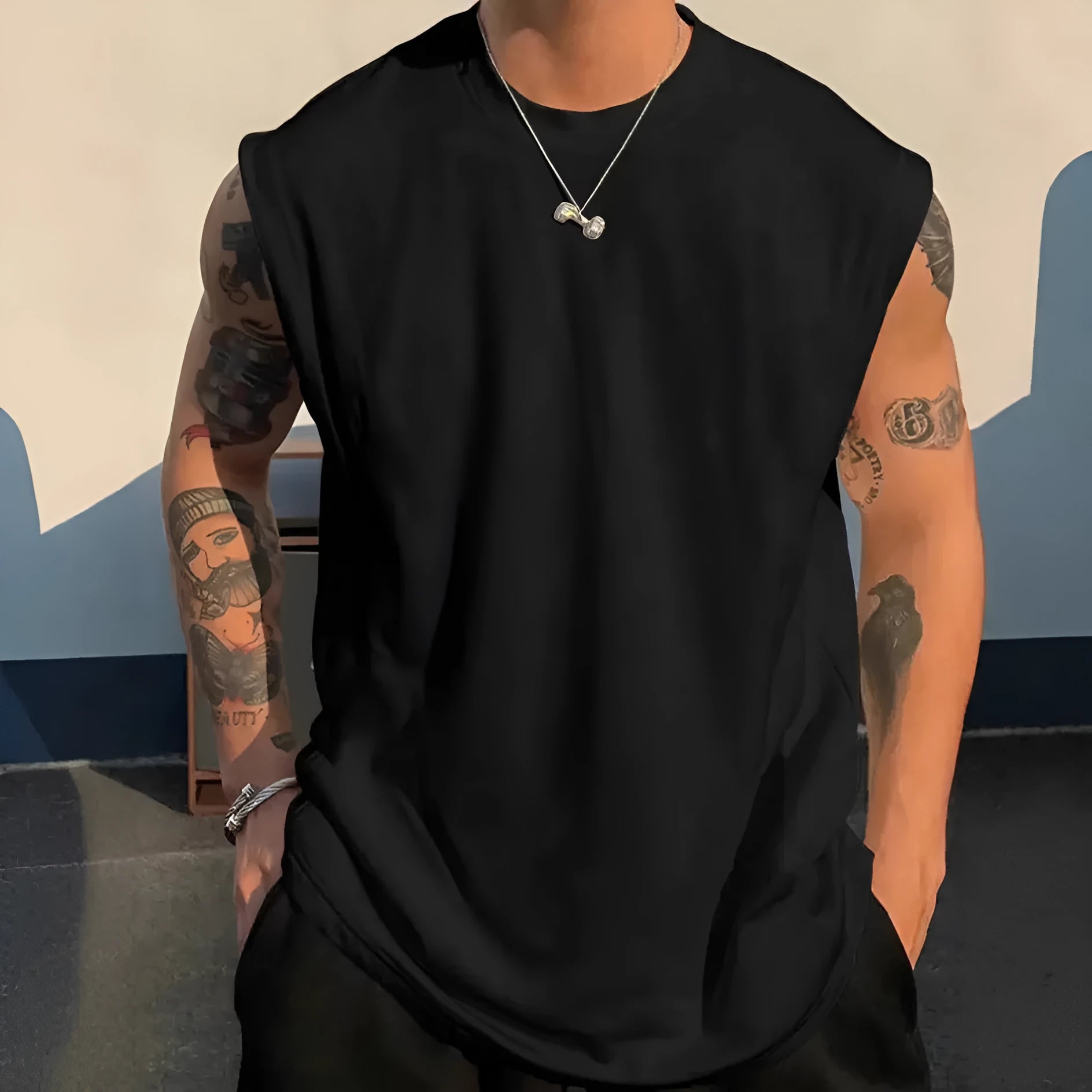 Man wearing a loose solid-colour cotton sleeveless pullover tank top.