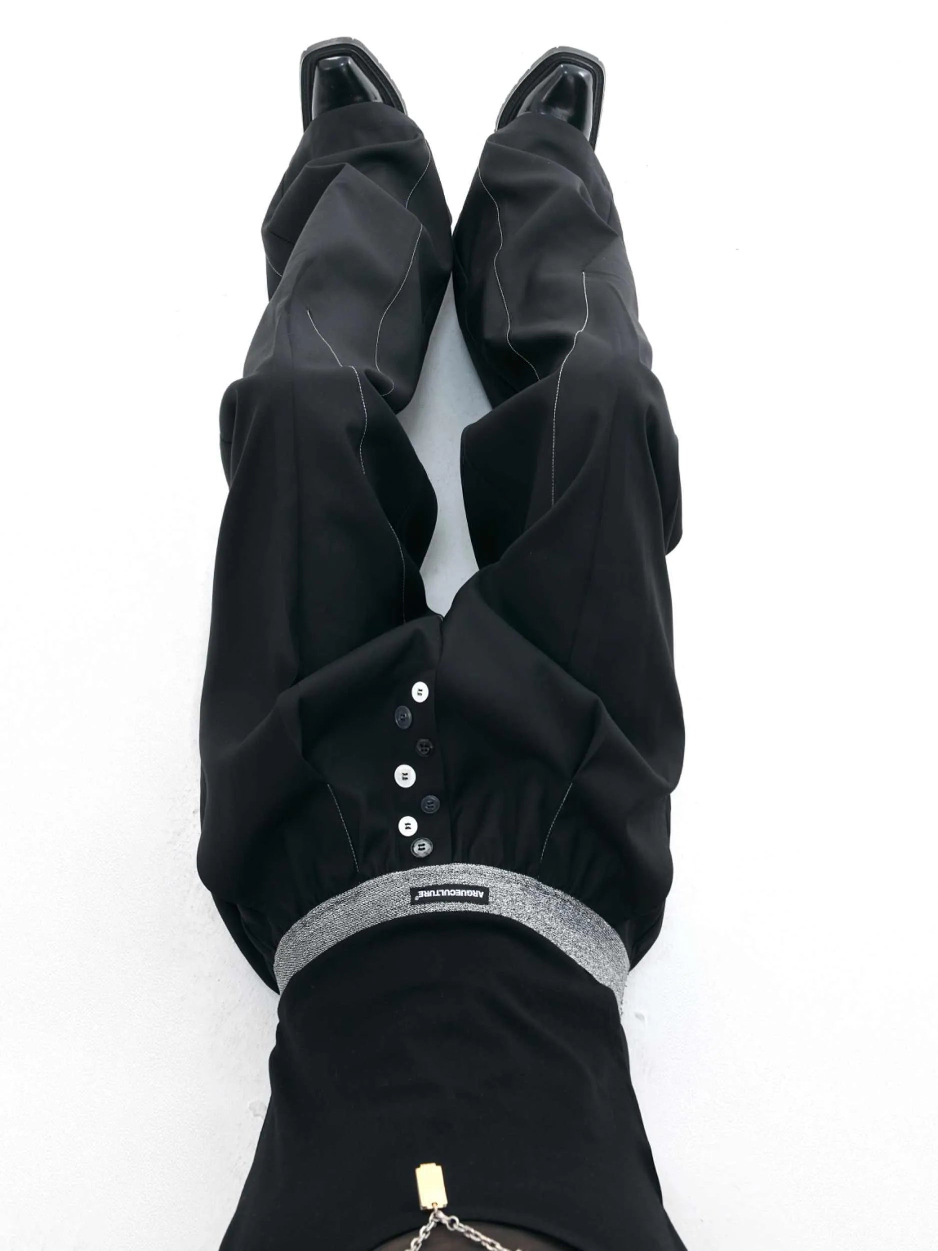 Men's high-waisted straight-leg casual trousers in black with button fly front, showing relaxed fit.