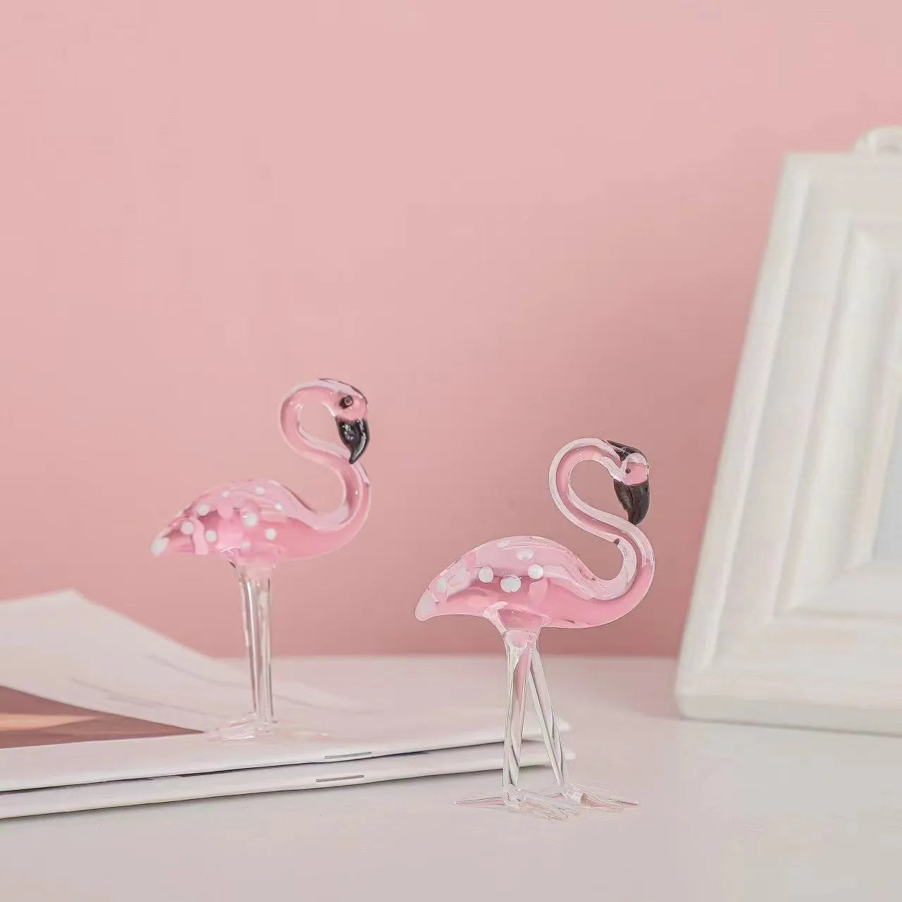 White crystal flamingo decorative ornaments with pink dots on a table