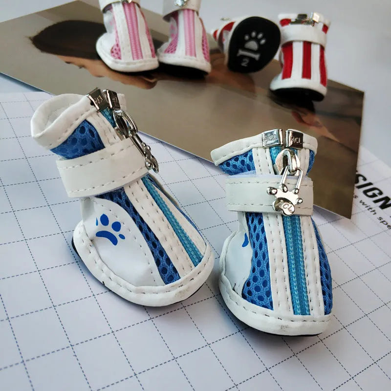Four blue cloth dog shoes with zipper closures and non-slip soles arranged together