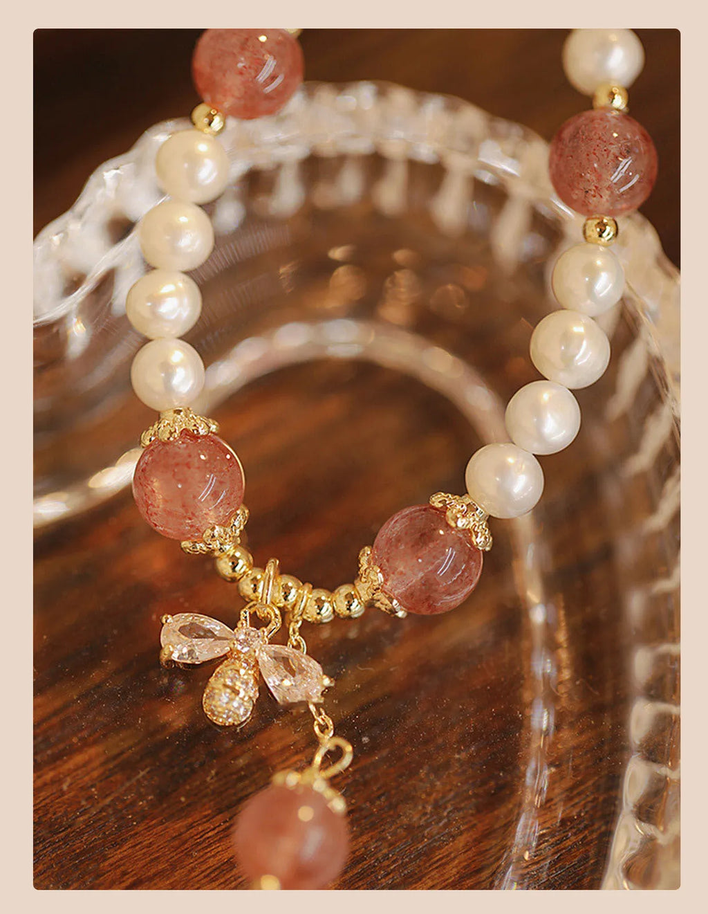 Women's handmade strawberry quartz and crystal bracelet with a decorative bow on a string of beads.