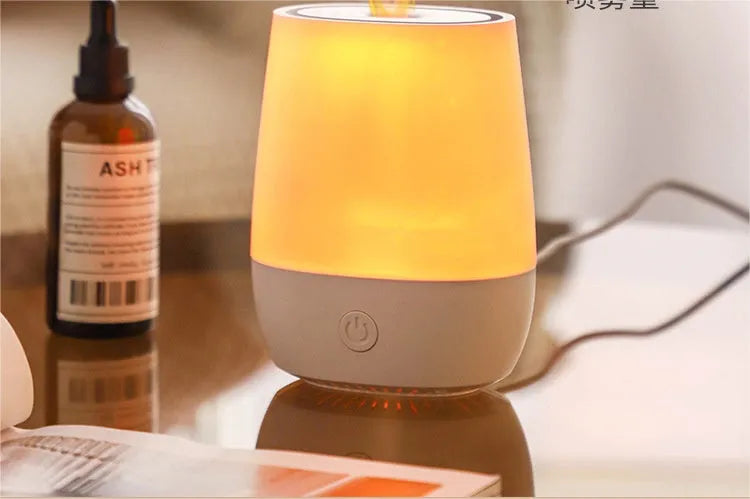 White USB aroma diffuser with simulated flame effect on a wooden surface.