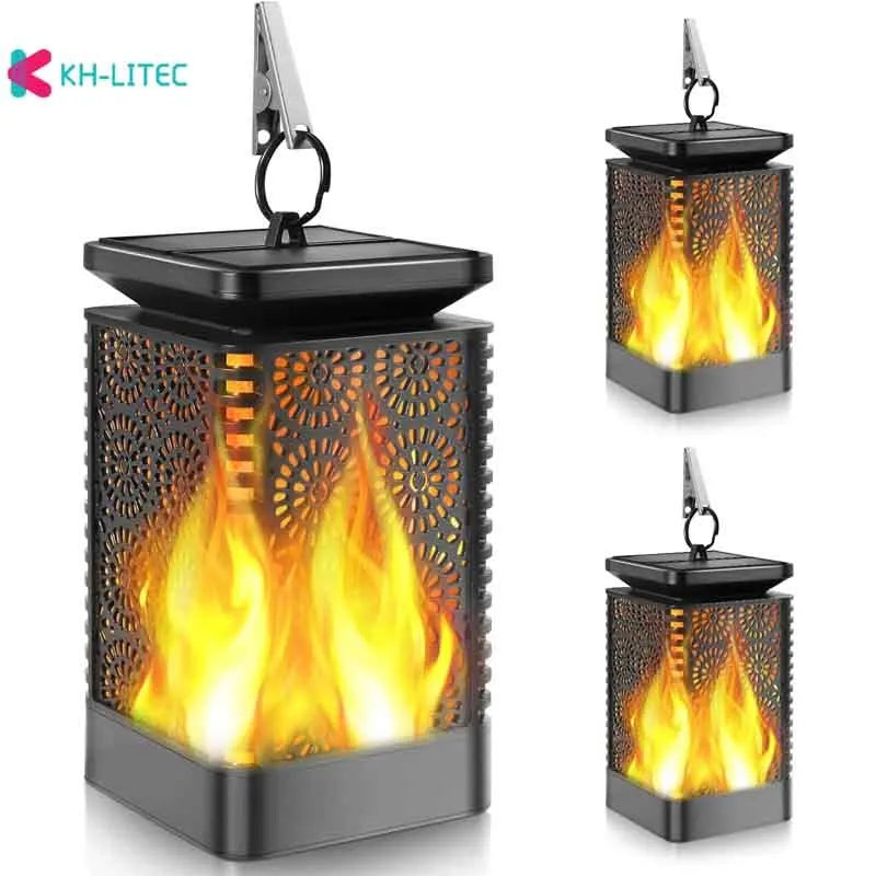 Set of four black solar-powered LED lanterns with flame flicker effect for outdoor garden use.