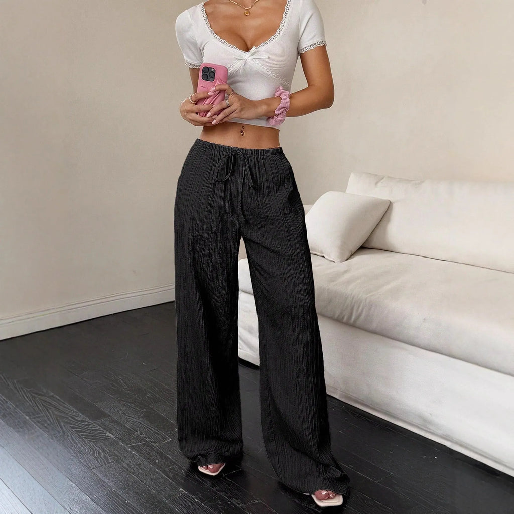Black wide leg women's trousers with a lace-up waist trimming detail on a mid waist.