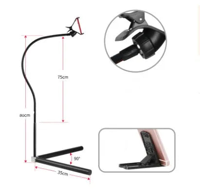 Black bedside mobile phone holder mounted on a bed frame with a phone securely clipped in place.