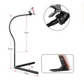 Black bedside mobile phone holder mounted on a bed frame with a phone securely clipped in place.